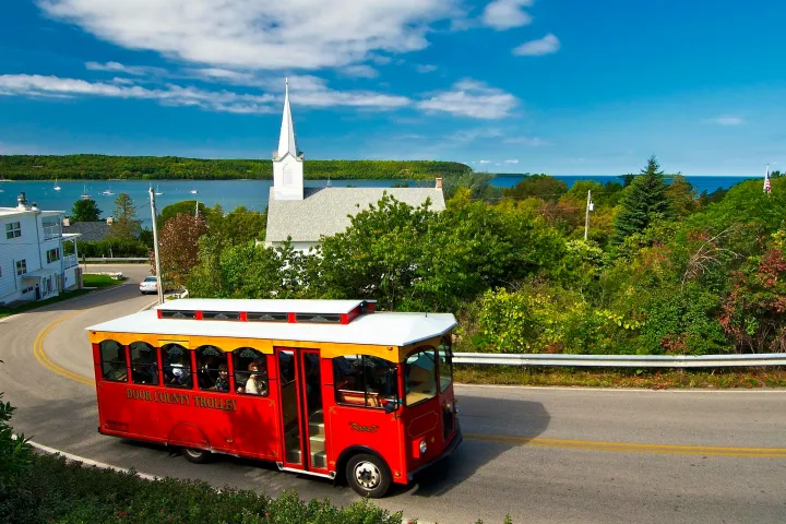 a red tour bus driving down the road