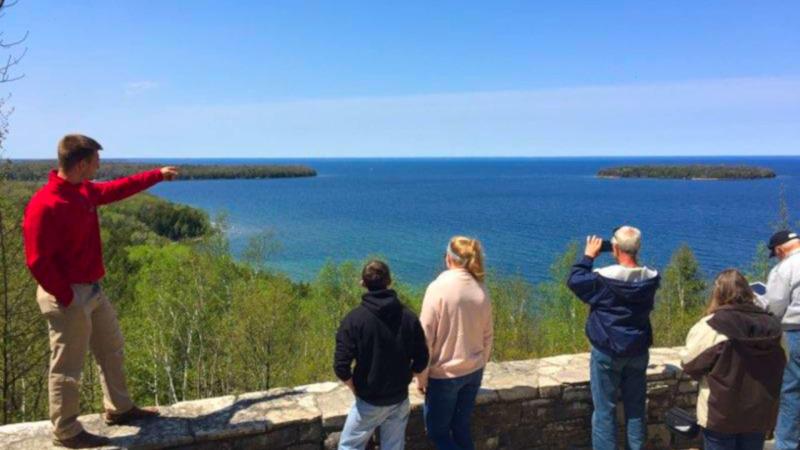 a group of people standing next to a body of water