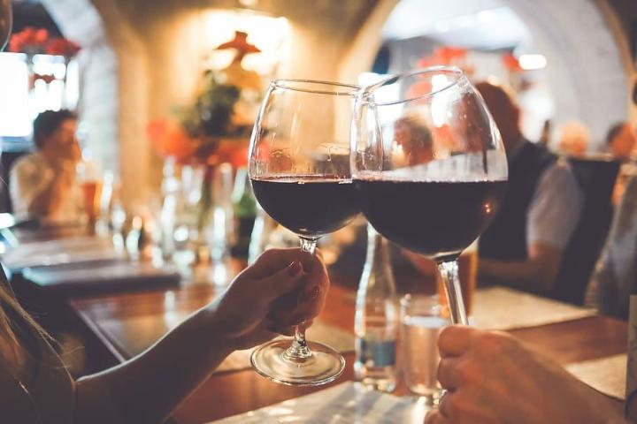 a woman sitting at a table with wine glasses