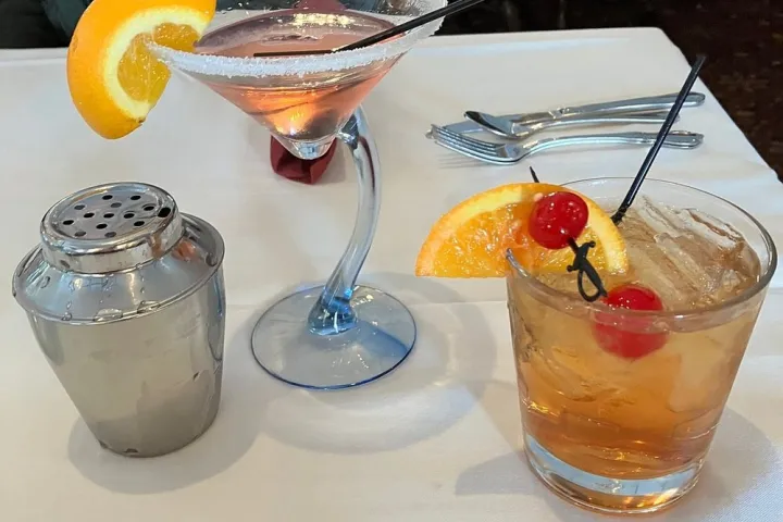 a person sitting at a table with a glass of orange juice