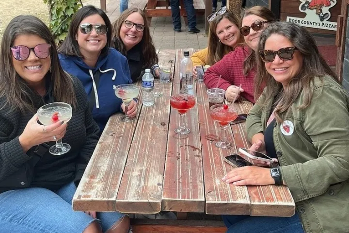 a group of people sitting at a table with wine glasses